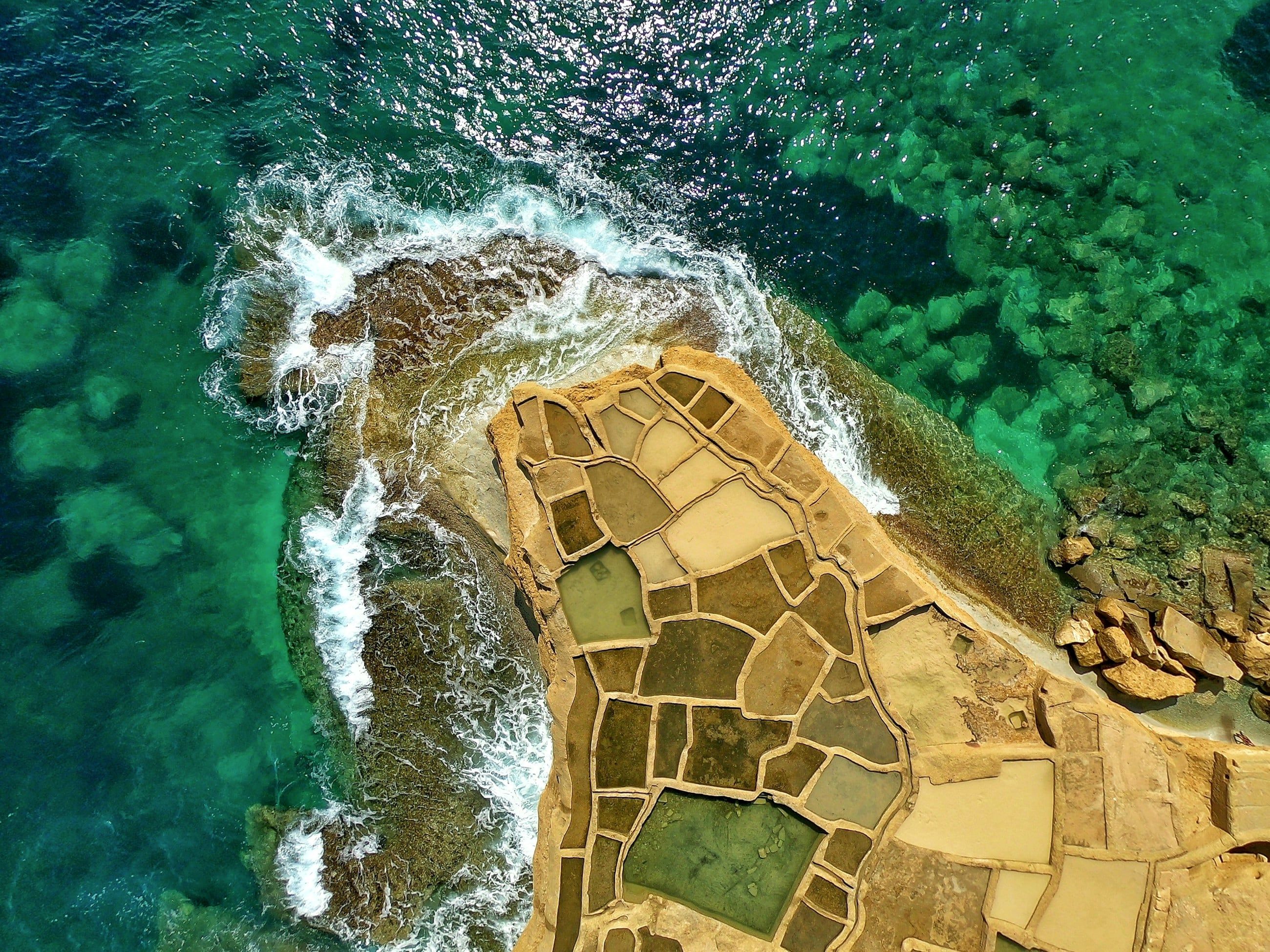 Salt pans cut into the rock on the Gozo coast, seen from above